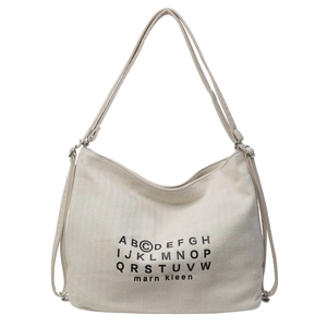 Front view of a minimalist cream canvas tote bag with black letter print and adjustable straps