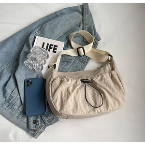 Vue détaillée du sac bandoulière plissé en nylon beige avec sangle réglable et cordon