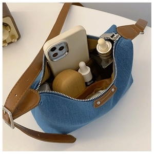 Top view of blue denim shoulder bag with brown leather strap showing interior capacity