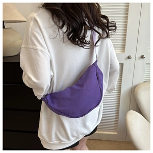 Purple crescent canvas crossbody bag shown on model for a casual everyday styling look