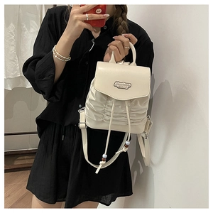 Detail of cream pleated mini backpack with fashion metal logo and drawstring closure