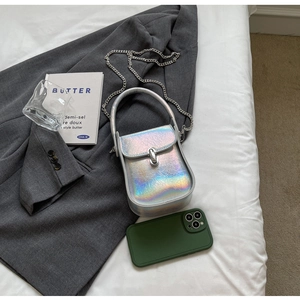 Macro shot of silver iridescent laser crossbody bag with chain and metallic texture