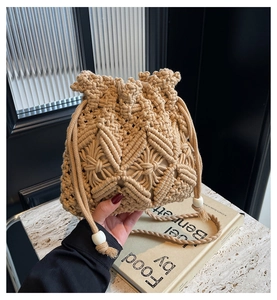 Detail of woven beige cotton bucket bag with intricate diamond patterns and drawstrings