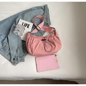 Vue détaillée du sac bandoulière rose plissé avec cordon de serrage et large sangle