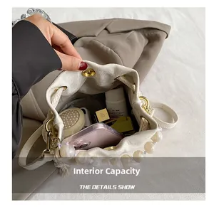 Detail showing internal capacity of white bucket bag with pearl handle and metal hardware