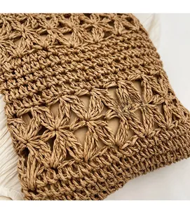 Macro shot of hand-woven straw bag showing floral hollow patterns and fabric lining