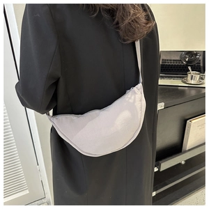 Detail of light grey pleated dumpling bag in nylon shown on model shoulder