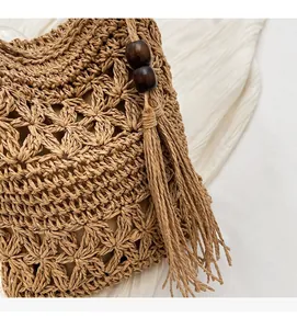 Close-up of star-patterned straw weave bucket bag with tassel and wood bead detail