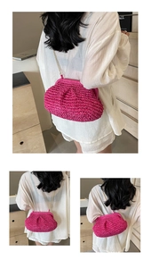 Detail of fuchsia woven shell bag with gold chain strap on a white shirt background