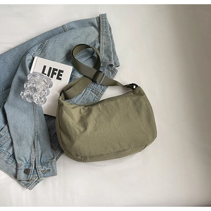 Détail du sac bandoulière plissé en nylon vert armée avec large sangle réglable