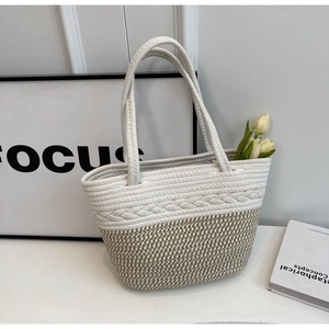Détail du sac cabas tissé bicolore avec texture tressée crème et motifs de couleur kaki
