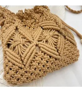 Detail of handmade khaki woven bucket bag showing intricate straw knit texture and strap