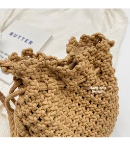 Detail view of khaki straw bucket bag featuring a secure drawstring design closure