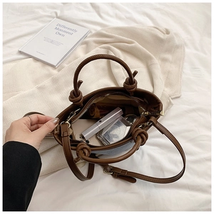 Detail of dark brown leather handbag interior showing storage for phone and cosmetics