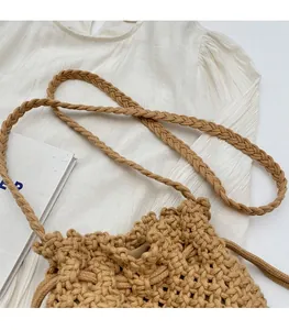 Detail of hand-woven straw bucket bag showing durable braided strap and rustic texture
