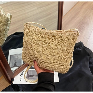 Detailed macro view of woven petal pattern on handmade straw bucket bag with zipper
