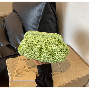 Detail of mint green woven shell bag featuring a gold chain and unique pleated straw texture