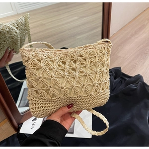 Close-up of woven straw bucket bag with floral hollow patterns and zipper closure