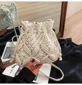 Detail of hand-woven beige bucket bag with intricate patterns and wooden bead drawstring