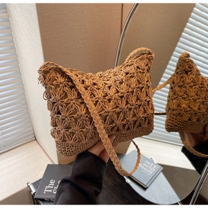 Detailed close-up of handmade woven straw bucket bag with hollow star pattern design