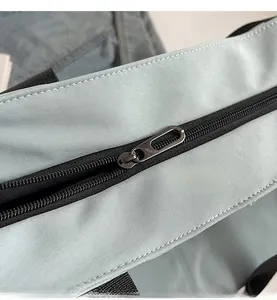 Close-up detail of smooth metal zipper and durable light blue canvas fabric on shoulder bag