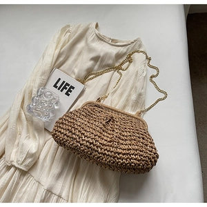 Detailed texture of straw weave crossbody bag with golden chain on elegant dress