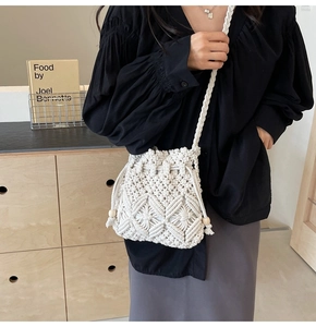 Detail of hand-woven beige bucket bag featuring diamond texture, drawstring and tassels