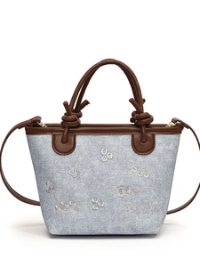 Light blue denim bucket bag with floral embroidery and brown leather handles