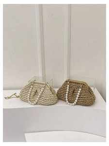 Detailed texture of straw woven handbag with large faux pearl handle and gold chain