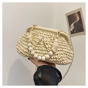 Detail of cream woven straw handbag with marble bead handle and gold chain strap