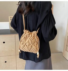 Detail of hand-woven beige macrame bucket bag with fringe drawstring and shoulder strap