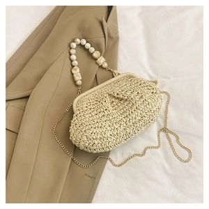 Detail of straw woven cloud bag featuring marble beads handle and gold metal chain