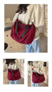 Detailed view of a large burgundy canvas tote bag with adjustable black shoulder strap