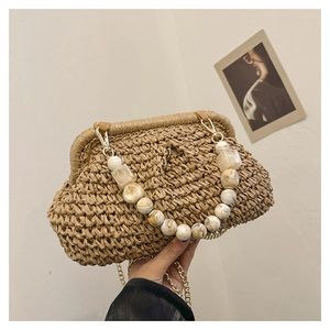 Detail of bohemian straw handbag featuring marble acrylic beads and gold chain strap