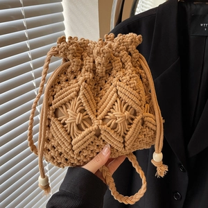 Handwoven straw bucket bag in caramel brown featuring bohemian crochet and wooden beads