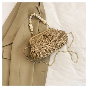 Detail of woven straw cloud bag featuring marbled resin beads and gold chain strap