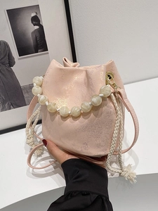 Pink pleated bucket bag with pearl handle and metallic texture for stylish summer outfits
