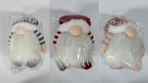 Close-up of three festive Christmas gnomes in sequined hats packed in clear protective bags