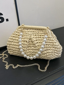 Handwoven beige straw bag with white pearl handle and detachable gold chain strap