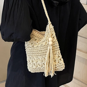 Handmade woven straw bucket bag with floral patterns and tassel details for summer beach