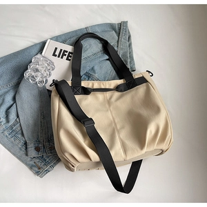 Detail of canvas shoulder bag with adjustable strap, styled with lifestyle props on white