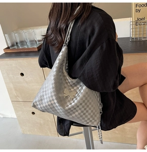 Detail of silver checkerboard shoulder bag with 3D butterfly buckle and chain strap