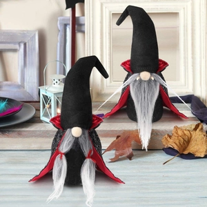 Makroaufnahme von Halloween-Vampir-Gnom-Puppen mit Umhängen auf Holzhintergrund