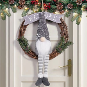 Christmas gnome wreath with welcome banner and pine decorations on a white door