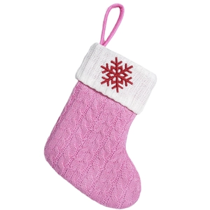 Pink knitted Christmas stocking with white cuff and embroidered red snowflake hanging