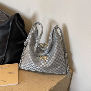 Silver checkered tote bag with golden bow ornament and chain strap for versatile wear