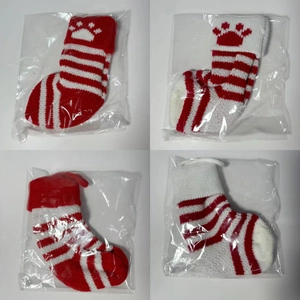 Close-up of knit Christmas pet stockings with paw prints in four red and white patterns