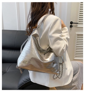 Dettaglio della borsa hobo argento metallizzato con fibbia a farfalla e catena