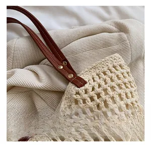 Detailed view of the woven tote bag with brown leather strap and gold rivet accents