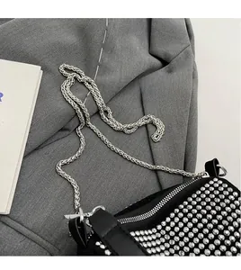 Detail of silver chain strap and beaded rhinestone texture on black crossbody bag